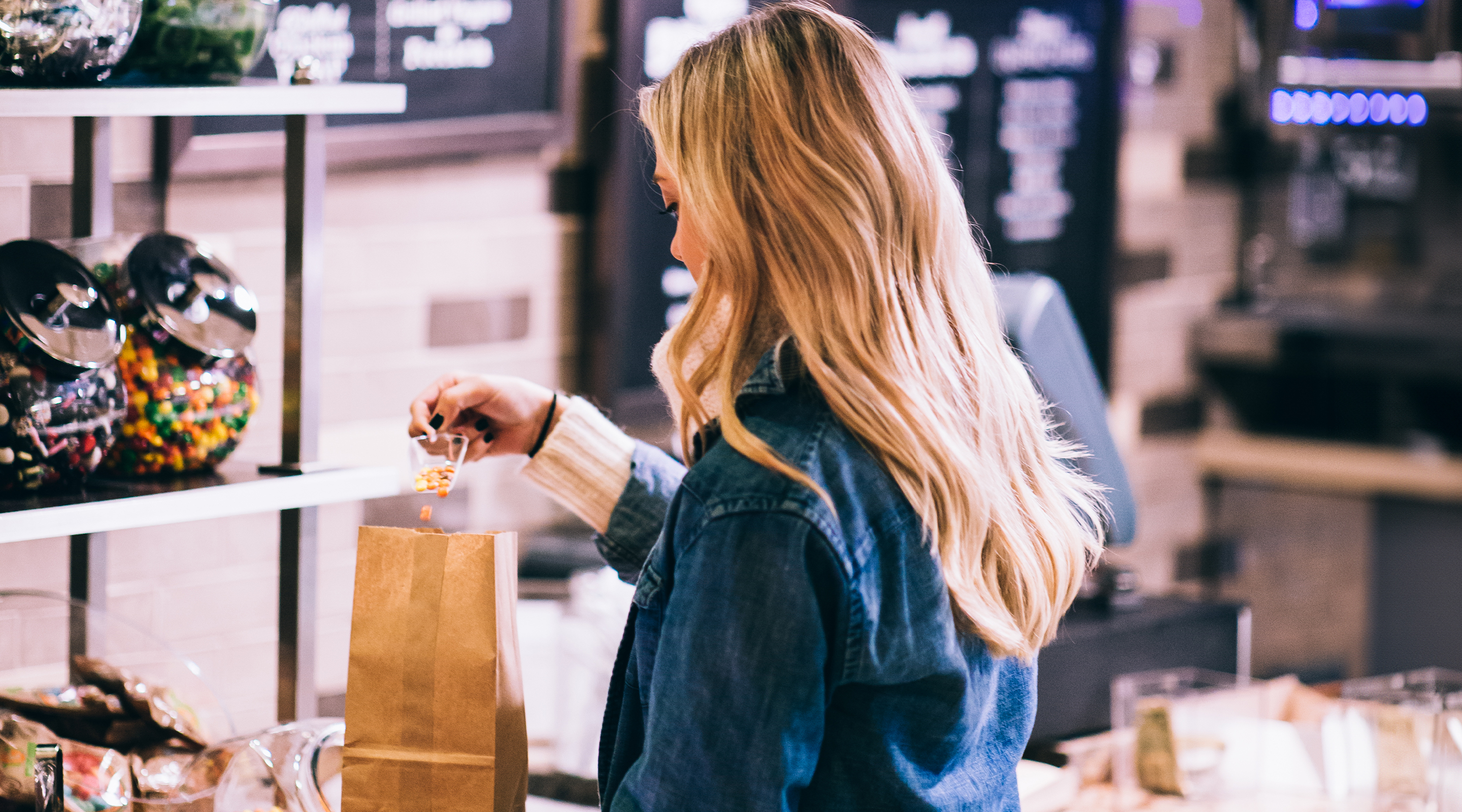 woman putting candy into a paper bag