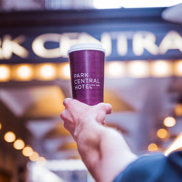 person holding Park Central Hotel New York branded cup