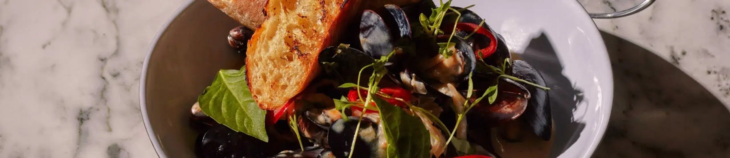 Mussels with toasted bread served at Twenty Sevens in Midtown Manhattan