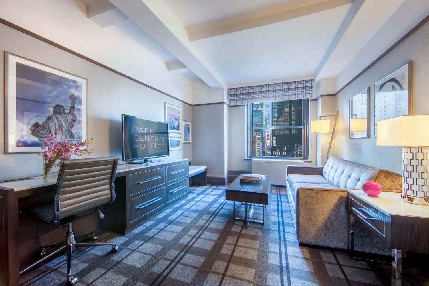 One-bedroom suite living area with city views at Park Central Hotel New York